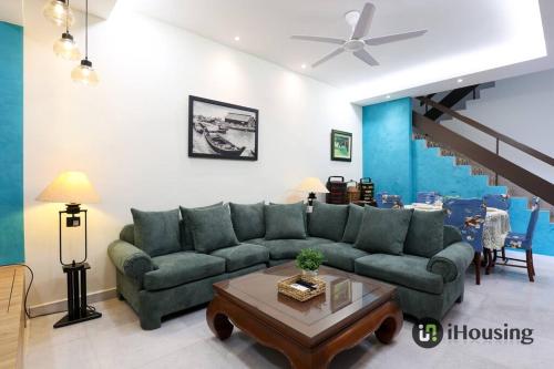 a living room with a green couch and a table at Klebang Modern Classic Chill House Melaka By I Housing in Melaka