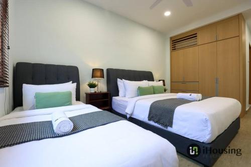 two beds sitting next to each other in a room at Klebang Modern Classic Chill House Melaka By I Housing in Melaka