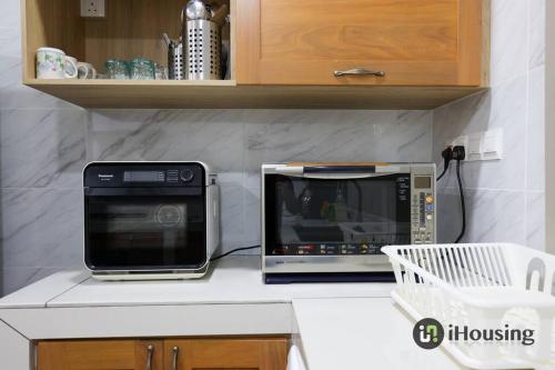 a microwave and a toaster oven on a kitchen counter at Klebang Modern Classic Chill House Melaka By I Housing in Melaka