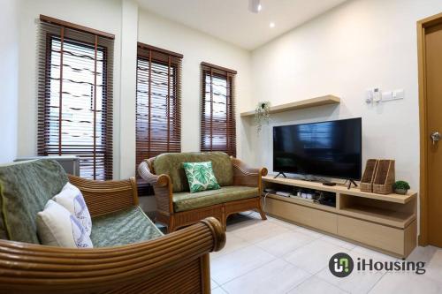 a living room with a television and two chairs at Klebang Modern Classic Chill House Melaka By I Housing in Melaka