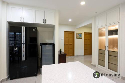 a kitchen with a black refrigerator and wooden cabinets at Klebang Modern Classic Chill House Melaka By I Housing in Melaka