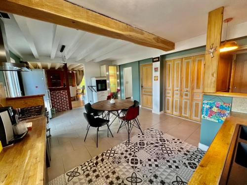 une cuisine et une salle à manger avec une table et des chaises dans l'établissement Villa de Simona, à Yvré-lʼÉvêque