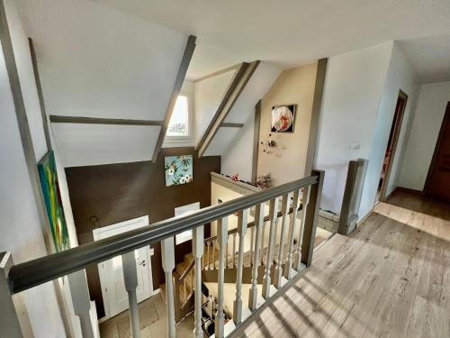 un escalier dans une maison aux murs blancs et au parquet dans l'établissement Villa de Simona, à Yvré-lʼÉvêque
