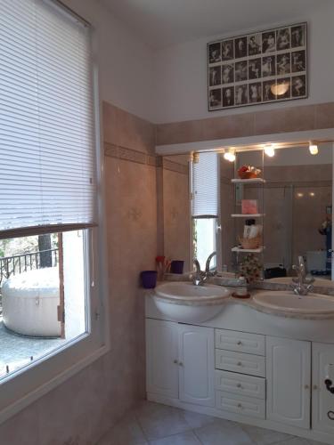 La salle de bains est pourvue de 2 lavabos et d'une grande fenêtre. dans l'établissement villa Kallisté, à Figanières