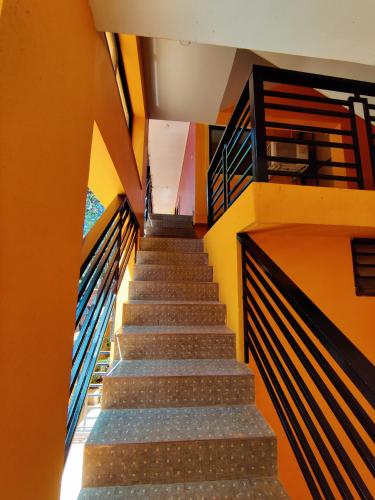 a flight of stairs in a building with orange walls at Sai Guru Guest House in Anjuna