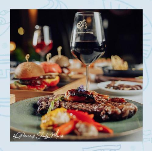 a plate of food and a glass of wine at Ios Hotel & Village Extension in El Alamein