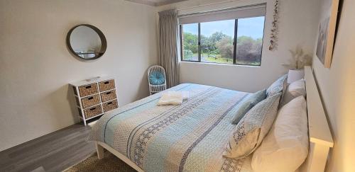 - une chambre avec un lit avec un miroir et une fenêtre dans l'établissement Ocean Crest On Pebbly - Winner 2024 Traveller Awards!, à Forster