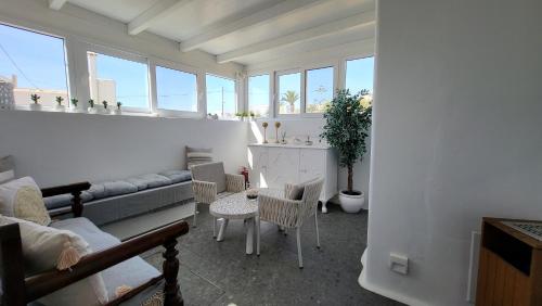 a living room with a couch and a table and chairs at Mykonos Double Luxury Mini Suites-With External Hot spa Adults only in Ano Mera