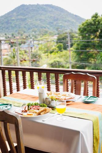 a table with a plate of food and glasses of orange juice at Samui Wooden Hill Resort in Lamai