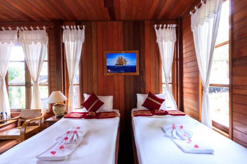 two twin beds in a room with windows at Samui Wooden Hill Resort in Lamai