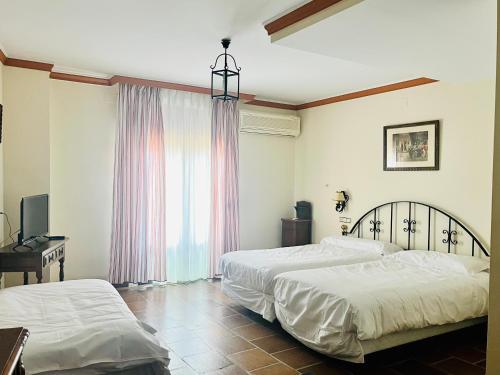 a bedroom with two beds and a window at Cella del Palancar in Motilla del Palancar