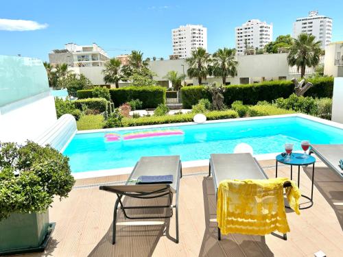 una piscina con due sedie e un tavolo di Luxury villa & private heatable pool in Albufeira ad Albufeira