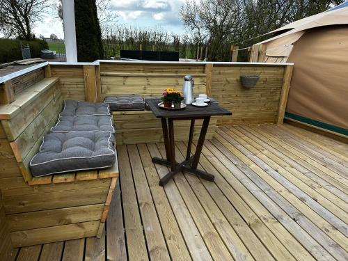 a patio with a table on a wooden deck at Romantic Luxus Glamping 1 in Idestrup