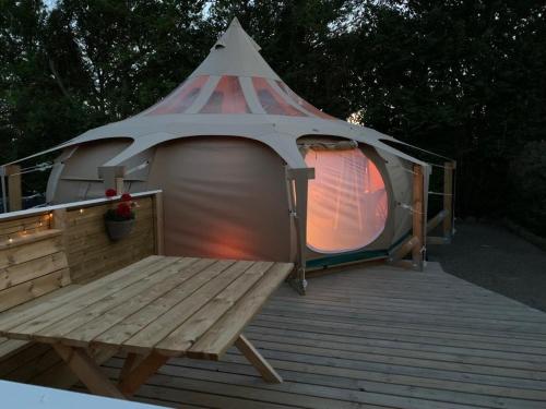 a gazebo with a bench on a wooden deck at Romantic Luxus Glamping 1 in Idestrup