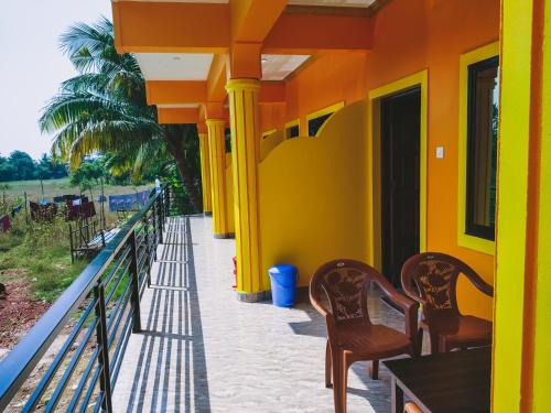 two chairs sitting on the porch of a house at Sai Guru Guest House in Anjuna