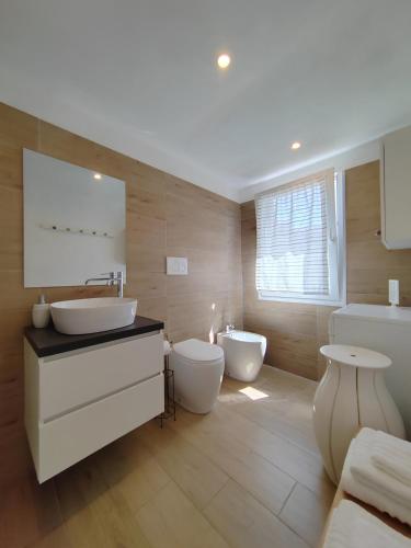 a bathroom with two sinks and a tub and a toilet at La Piccola Casa di Via Ricotti in Castelguglielmo
