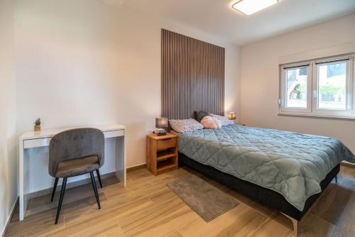 a bedroom with a bed and a desk and a chair at Apartmani Krtica 1 in Vrbnik
