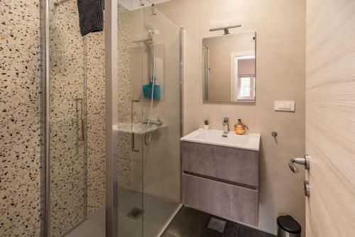 a bathroom with a sink and a glass shower at Apartmani Krtica 1 in Vrbnik
