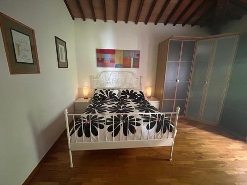 um quarto com uma cama com um edredão preto e branco em La Loggia del Ciliegio in Chianti em Montespertoli