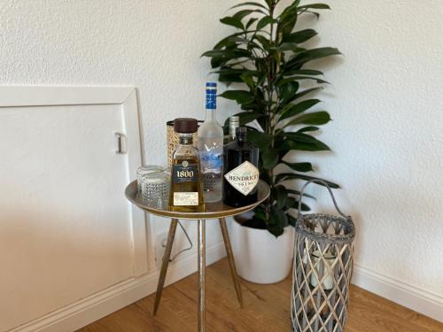 a table with bottles of wine and a plant at Ocean Escape - Teil der HolidayEscapes Kollektion in Timmendorfer Strand