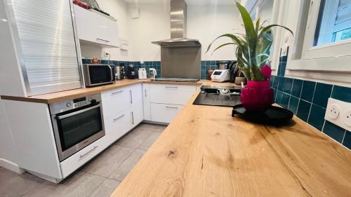 a kitchen with a wooden table with a vase on it at Charmante maison au Nord de Paris piscine chauffée in Argenteuil