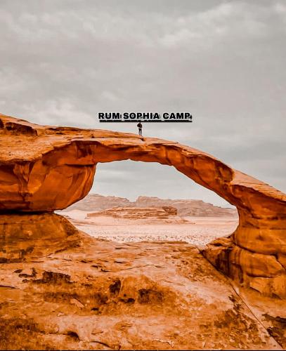 a person standing under an arch in the desert at Rum Sophia camp in Wadi Rum
