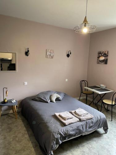 Appart’hôtel L’aiglon في سان-كلود: غرفة نوم عليها سرير وفوط