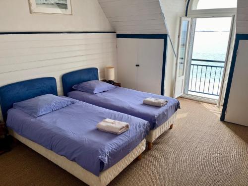 two beds in a room with a window at La Villa Ker Mat in Larmor-Plage