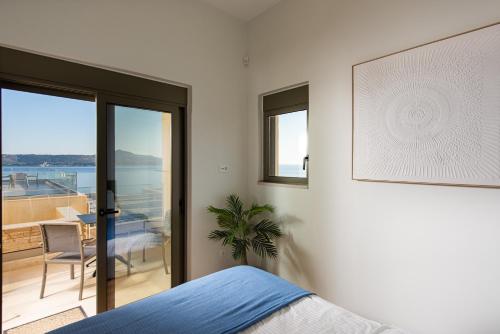ein Schlafzimmer mit Bett und Meerblick in der Unterkunft Seascape Kalyves in Kalyves