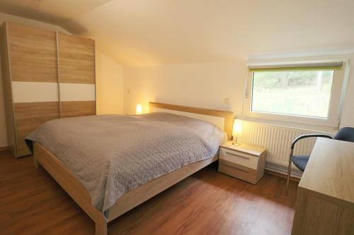 ein Schlafzimmer mit einem großen Bett und einem Fenster in der Unterkunft Haus Sonnentau in Monschau