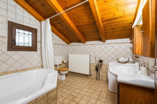 a bathroom with a tub and a sink and a toilet at The House of Love in Tragaki