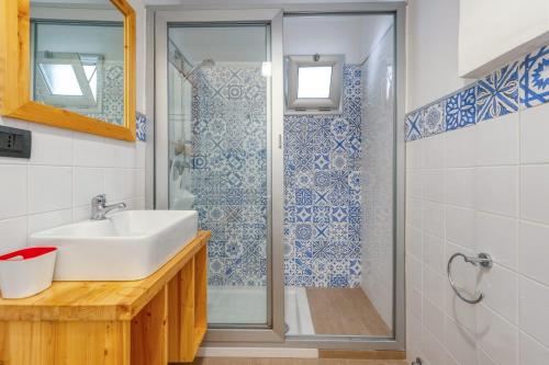 un baño con lavabo y ducha en SAINT BLUE BEACH, en Torre San Gennaro