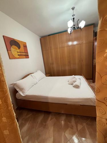 um quarto com uma cama e uma cabeceira em madeira em Cobo Apartment's em Përmet