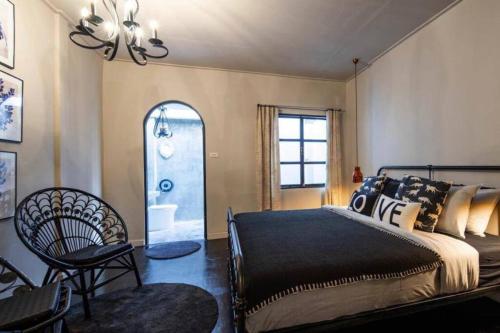 a bedroom with a bed and a chair and a window at Beautiful 3 Bedroom Baroque House near Asoke BTS in Bangkok