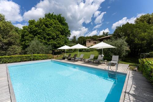 a swimming pool with two chairs and umbrellas at Borgo dei Fondi in Siena