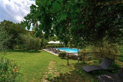 un cortile con piscina e un albero di Borgo dei Fondi a Siena
