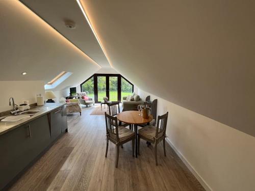 a kitchen and dining room with a table and chairs at The Stable, Grove End Farm in Petworth
