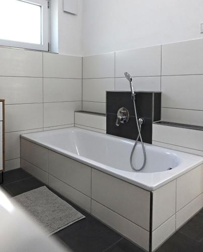 a bath tub with a shower in a bathroom at ELYs-Home in Isny im Allgäu