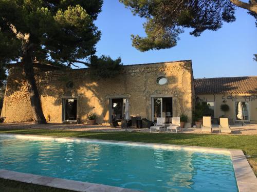 une maison avec piscine devant un immeuble dans l'établissement Le Moulin, à Murviel
