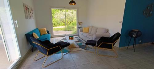 - un salon avec des chaises et un canapé dans l'établissement La Villa Lyne - villa moderne 4 chambres 8 personnes clim, à Lèzan