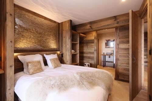 1 dormitorio con 1 cama grande y paredes de madera en Résidence l'Insolite, en Font-Romeu-Odeillo-Via