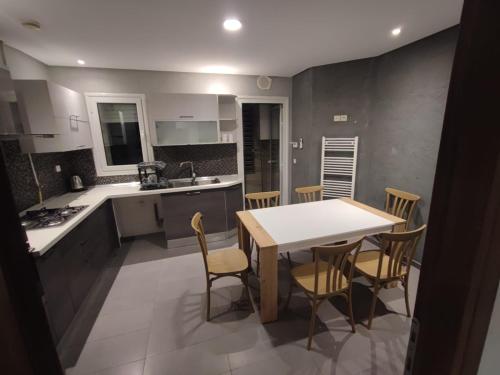 a kitchen and dining room with a table and chairs at Le flamand du lac 2 in La Goulette