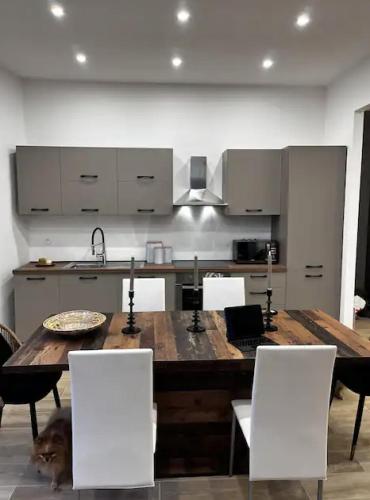 - une cuisine avec une table en bois et des chaises blanches dans l'établissement Aux portes de la Principauté, à Roquebrune-Cap-Martin