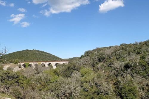 a bridge on top of a hill with trees at Gîtes du Mas Champion - Piscine, Soleil, Nature & Calme - groupes in Saint-Just-et-Vacquières