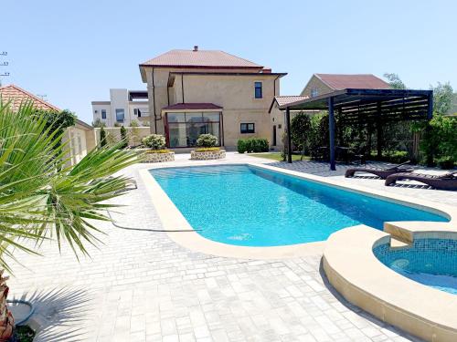 a swimming pool in front of a house at Villa Gilavar in Baku