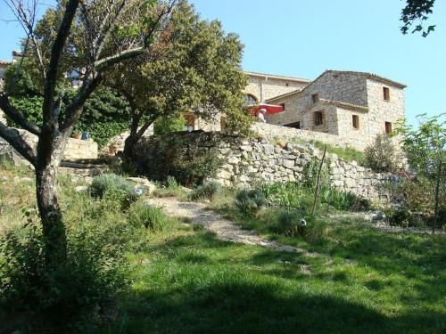 a stone wall in front of a building at Gîtes du Mas Champion - Piscine, Soleil, Nature & Calme - groupes in Saint-Just-et-Vacquières