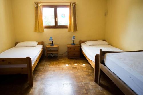 two beds in a room with a window at Gîtes du Mas Champion - Piscine, Soleil, Nature & Calme - groupes in Saint-Just-et-Vacquières