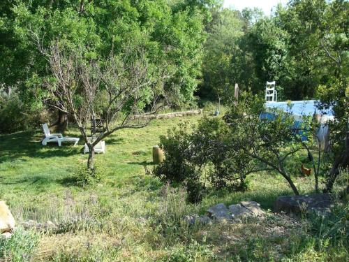 a garden with a tree and a bench in the grass at Gîtes du Mas Champion - Piscine, Soleil, Nature & Calme - groupes in Saint-Just-et-Vacquières