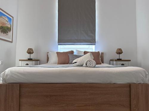 a bedroom with a large bed with white sheets and pillows at The Beach House in Birżebbuġa