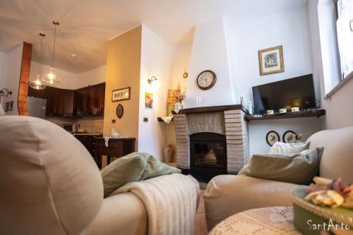 a living room with two couches and a fireplace at SantAntò nel cuore di Trivigno 120 mt in Trivigno